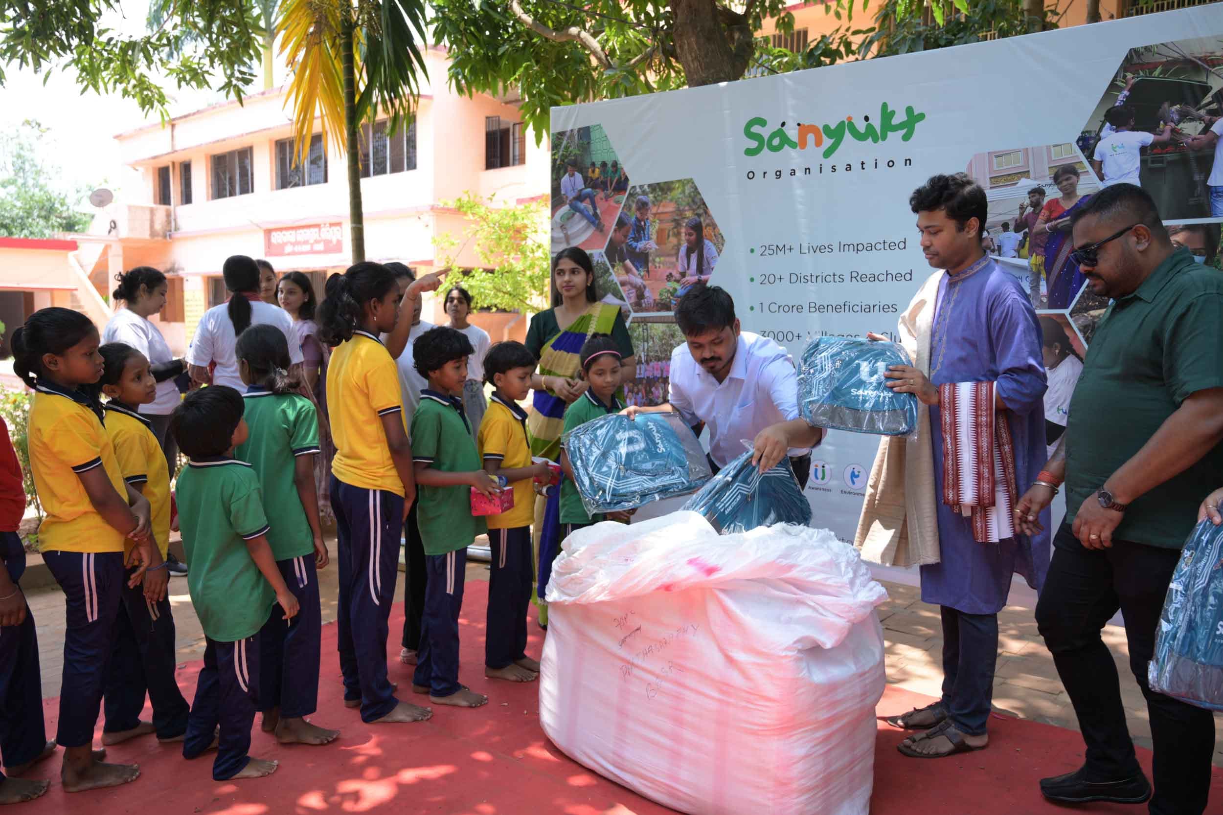 Sanyukt team distributing school backpacks to children under a CSR partnership