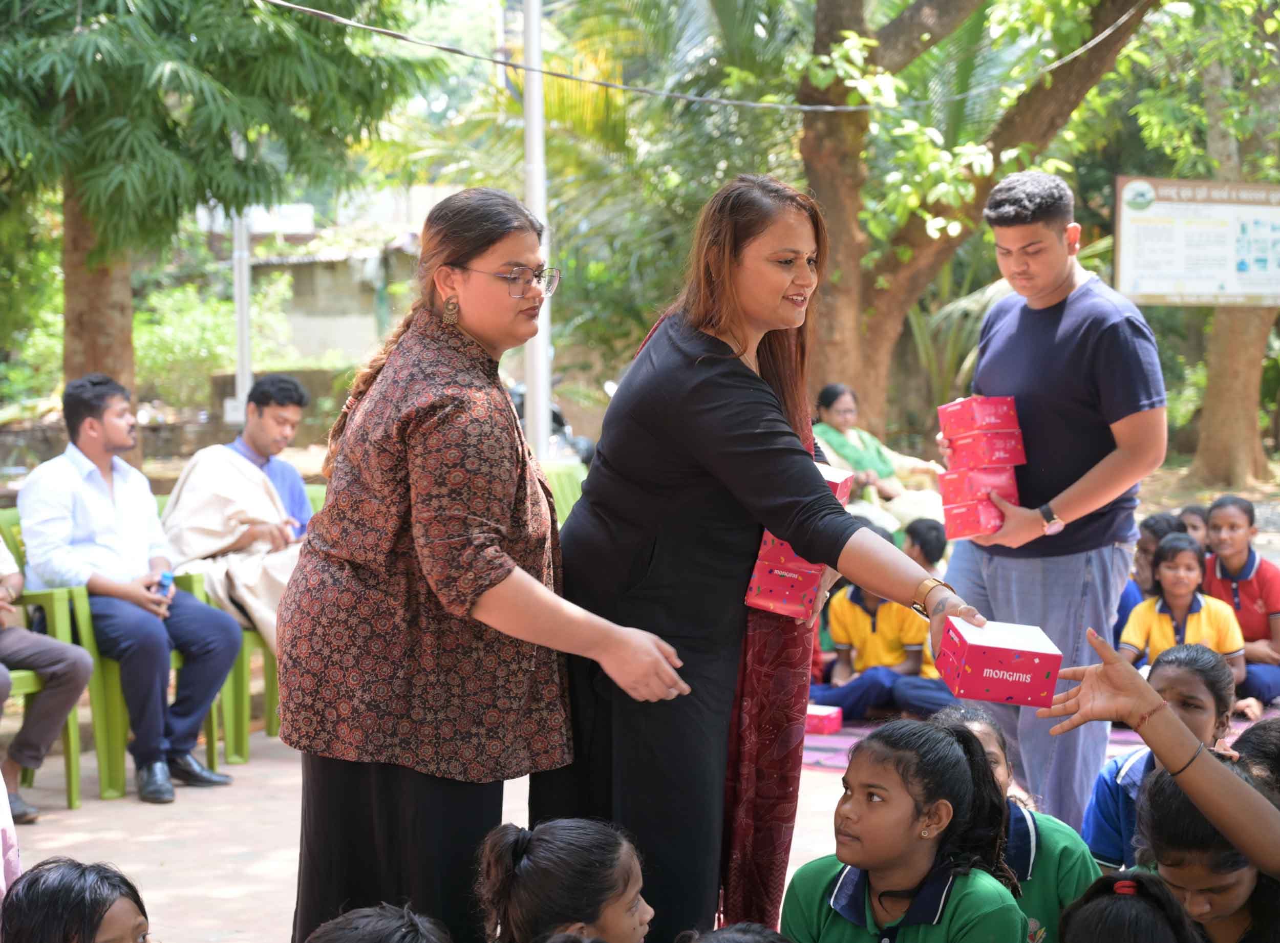 Sanyukt volunteers distributing sweets to children at a community event