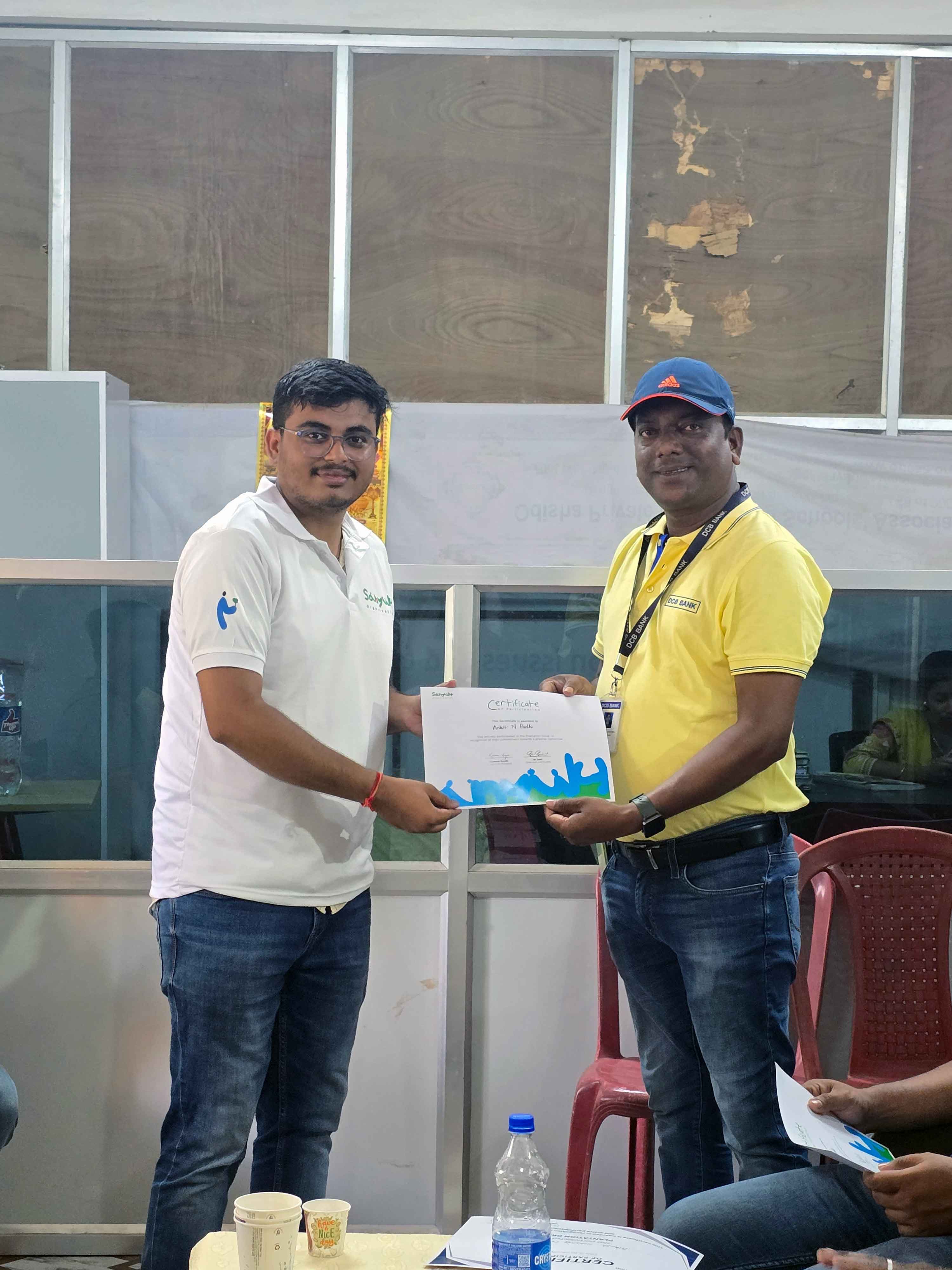 Sanyukt volunteer presenting a certificate of appreciation to a DCB Bank partner