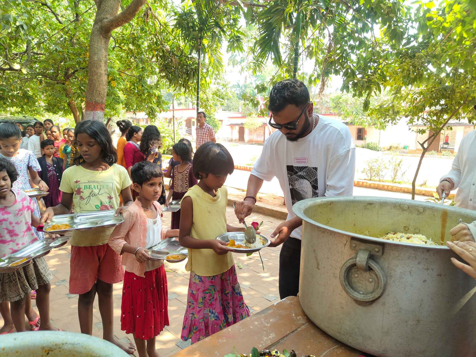 Sanyukt volunteer serving food to children at a community outreach event