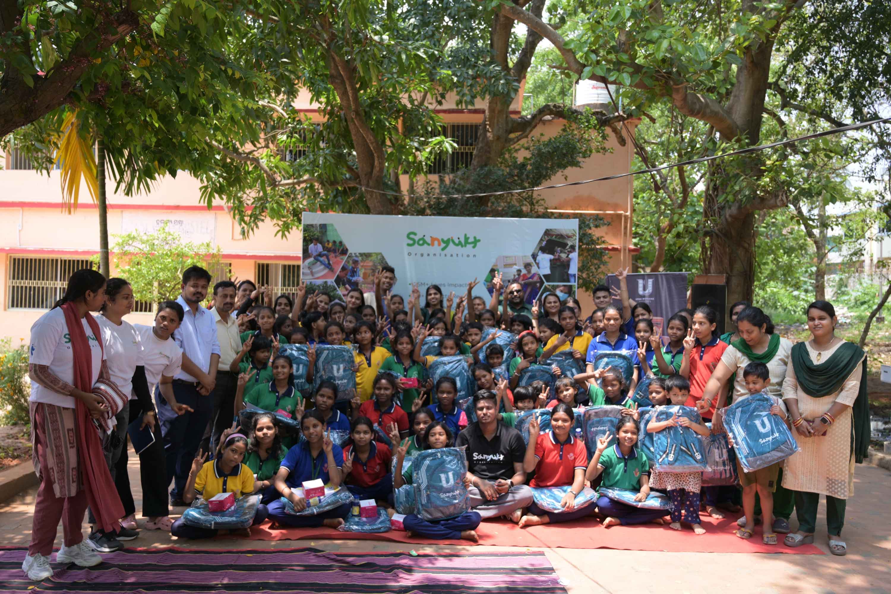 Sanyukt volunteers distributing school backpacks to children as part of a CSR partnership