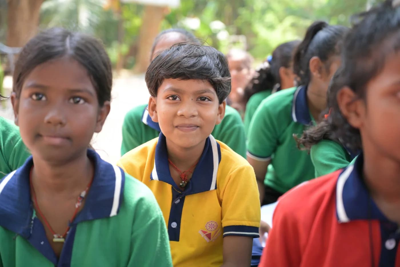 Children in Sanyukt program uniforms smiling together outdoors